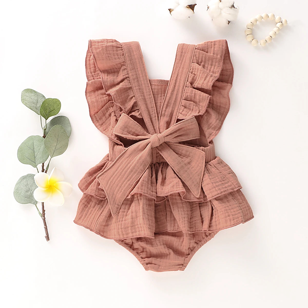 BabyLove Ruffled Jumpsuit at BubeBaby, perfect for baby girls aged 0-18 months. Made from soft cotton and polyester, this fashionable romper features a stylish O-neck and ruffled design.  it's ideal for spring and autumn