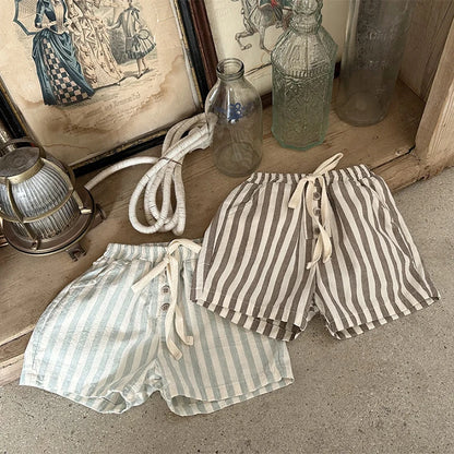 Shop our BabyLove Vintage Striped Shorts at BubeBaby. Perfect for summer, these unisex shorts feature a European and American style with a solid pattern. Made from soft cotton, they fit true to size and come in sizes ranging from 6-12m to 4-5T. Available in coffee, green, and beige. Ideal for ages 0-6 years