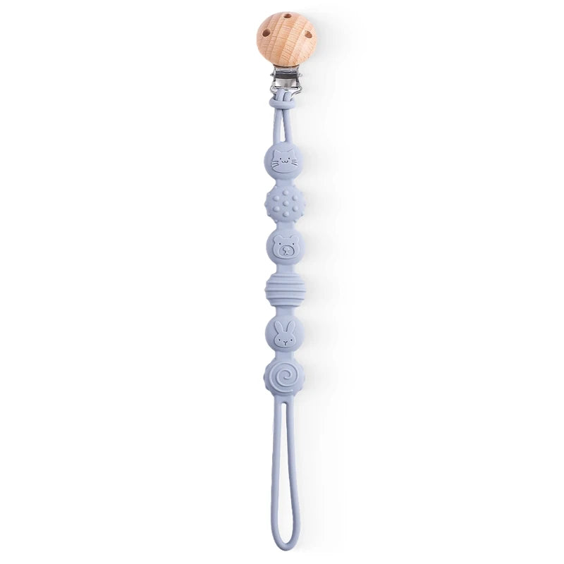  BabyLove Montessori Beech Wood and Silicone Beaded Pacifier Clip, a 20cm durable, BPA-free, phthalate-free, and latex-free accessory for babies aged 0-36 months. Features a solid color, wooden clip, and silicone strap. Versatile as a pacifier holder, soother chain, or teether toy. Safe and stylish design