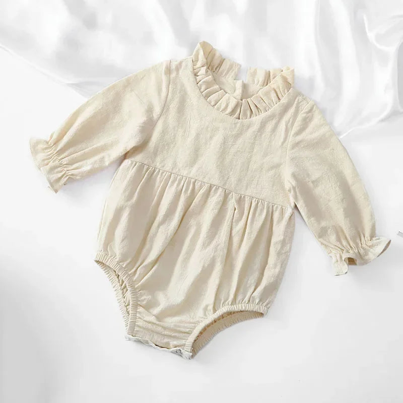 Bubebaby BabyLove Cotton Ruffled Long Sleeve buttoned Romper.  A cute and cozy baby romper made from soft cotton fabric, featuring long sleeves, a ruffled collar and wrists, with a snap closure for easy dressing. 