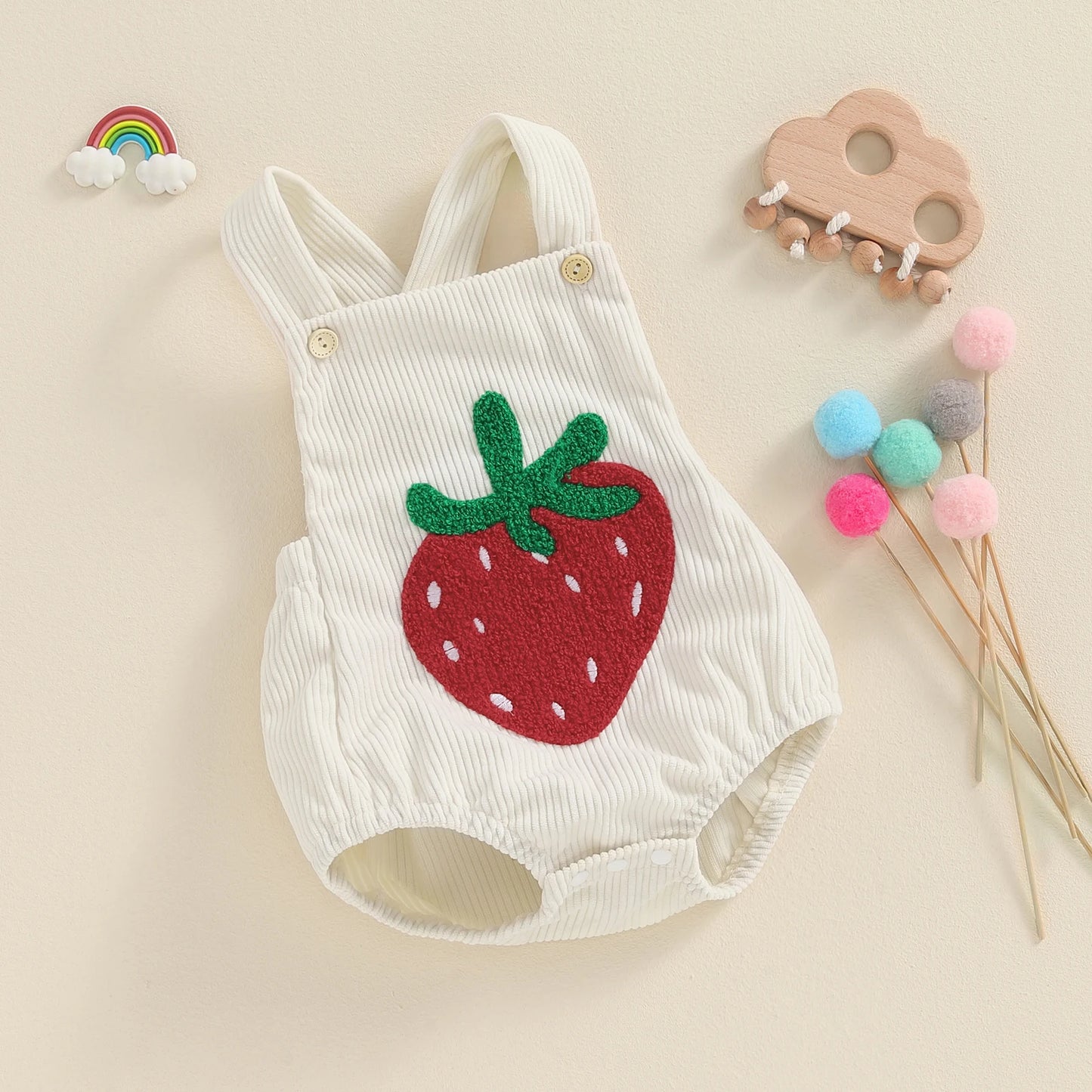 Keep your baby girl stylish and comfy with our BabyLove Floral Rainbow and Strawberry Romper! Perfect for ages 0-12 months, this sleeveless romper features a square neck, playful patterns, and a soft cotton-polyester blend. Lightweight and breathable, it's ideal for summer days. Fits true to size with covered button closures