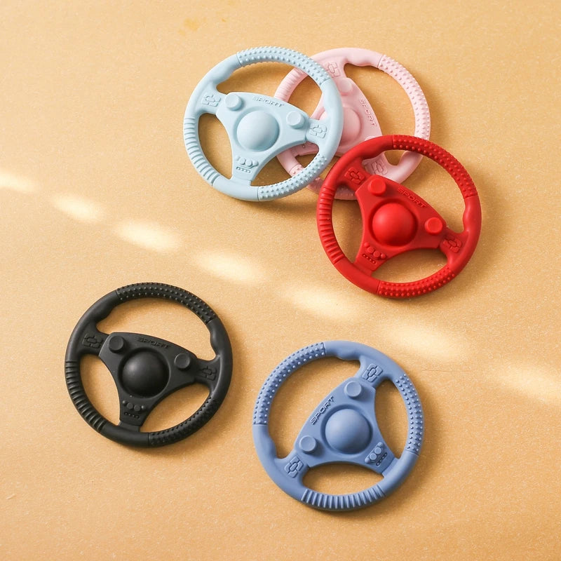 Silicone Bubebaby BabyLove Teething Toy Car Wheel – A fun and safe teether for babies, designed as an analog steering wheel. Made from 100% silicone, it's latex, nitrosamine, phthalate, BPA, and PVC free. Suitable for infants from 0 to 36 months. Available in various colors and comes in single packaging