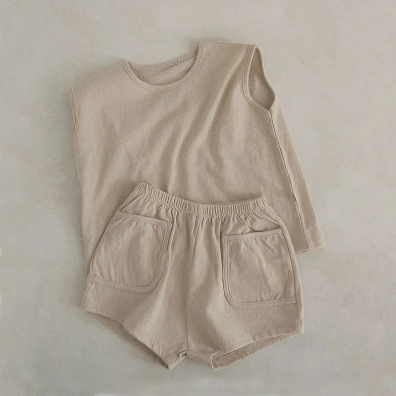 Discover the BabyLove Summer Suit at BubeBaby, featuring a vest set made from 100% cotton. This sleeveless outfit fits true to size and is perfect for summer. Available in sizes for babies 0-24 months, it includes a pullover shirt and shorts with a solid pattern. Shop now for stylish and comfortable summer wear