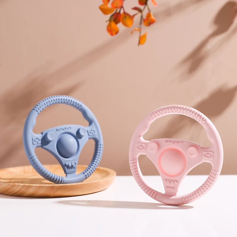 Silicone Bubebaby BabyLove Teething Toy Car Wheel – A fun and safe teether for babies, designed as an analog steering wheel. Made from 100% silicone, it's latex, nitrosamine, phthalate, BPA, and PVC free. Suitable for infants from 0 to 36 months. Available in various colors and comes in single packaging