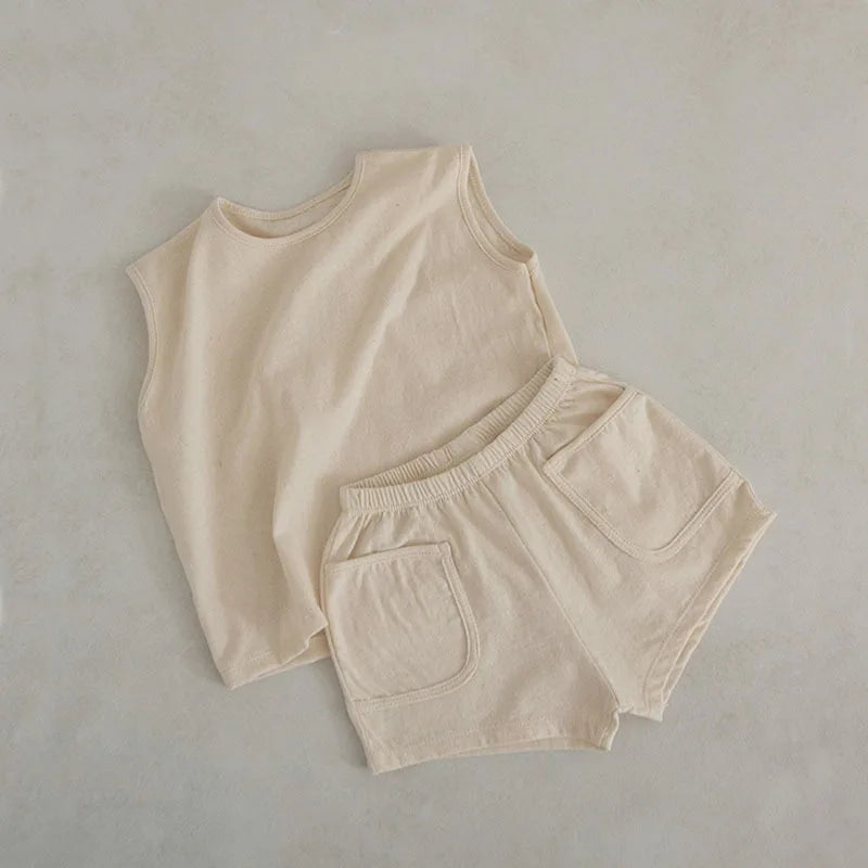 Discover the BabyLove Summer Suit at BubeBaby, featuring a vest set made from 100% cotton. This sleeveless outfit fits true to size and is perfect for summer. Available in sizes for babies 0-24 months, it includes a pullover shirt and shorts with a solid pattern. Shop now for stylish and comfortable summer wear