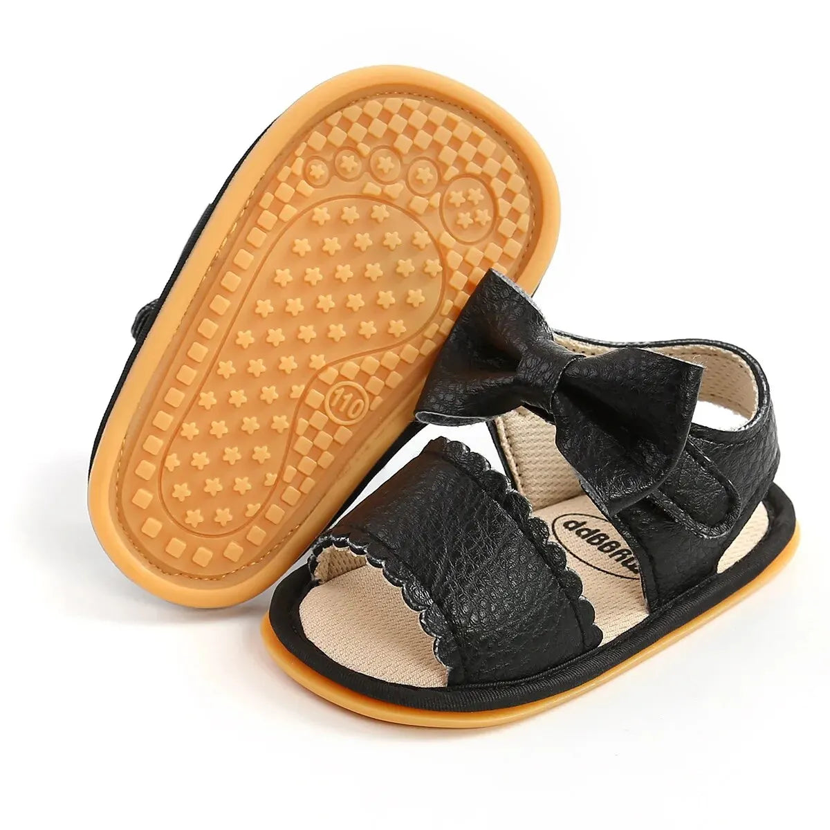 A cute pair of Bubebaby BabyLove  faux leather sandals for infants featuring an adorable bow detail. The sandals are designed for comfort and style, perfect for little ones to wear during warm weather. The adjustable strap ensures a secure fit while the soft sole provides cushioning for tiny feet