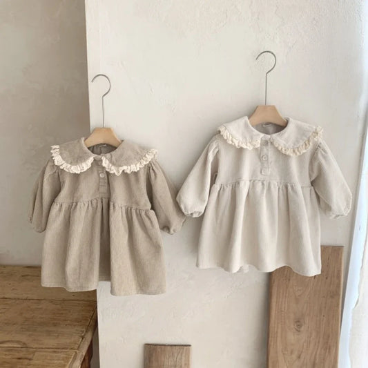 BabyLove Corduroy Peter Pan Collar Dress - A charming baby dress made from soft corduroy fabric, featuring a classic Peter Pan collar and delicate detailing, perfect for special occasions or everyday wear