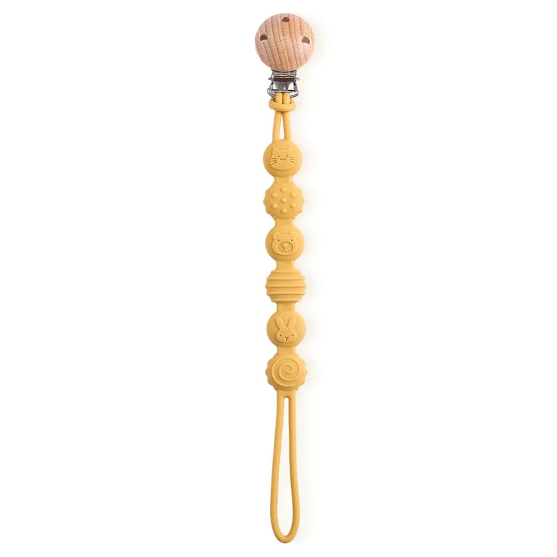 BabyLove Montessori Beech Wood and Silicone Beaded Pacifier Clip, a 20cm durable, BPA-free, phthalate-free, and latex-free accessory for babies aged 0-36 months. Features a solid color, wooden clip, and silicone strap. Versatile as a pacifier holder, soother chain, or teether toy. Safe and stylish design