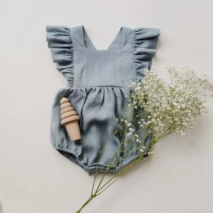 Shop BabyLove Ruffled Romper at BubeBaby, perfect for baby girls aged 0-24 months. Made from soft cotton, this sleeveless romper features a ruffled design and a covered button closure. Available in sizes for 3-24 months, it fits true to size and is ideal for summer