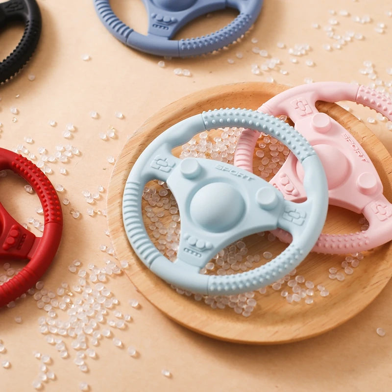 Silicone Bubebaby BabyLove Teething Toy Car Wheel – A fun and safe teether for babies, designed as an analog steering wheel. Made from 100% silicone, it's latex, nitrosamine, phthalate, BPA, and PVC free. Suitable for infants from 0 to 36 months. Available in various colors and comes in single packaging