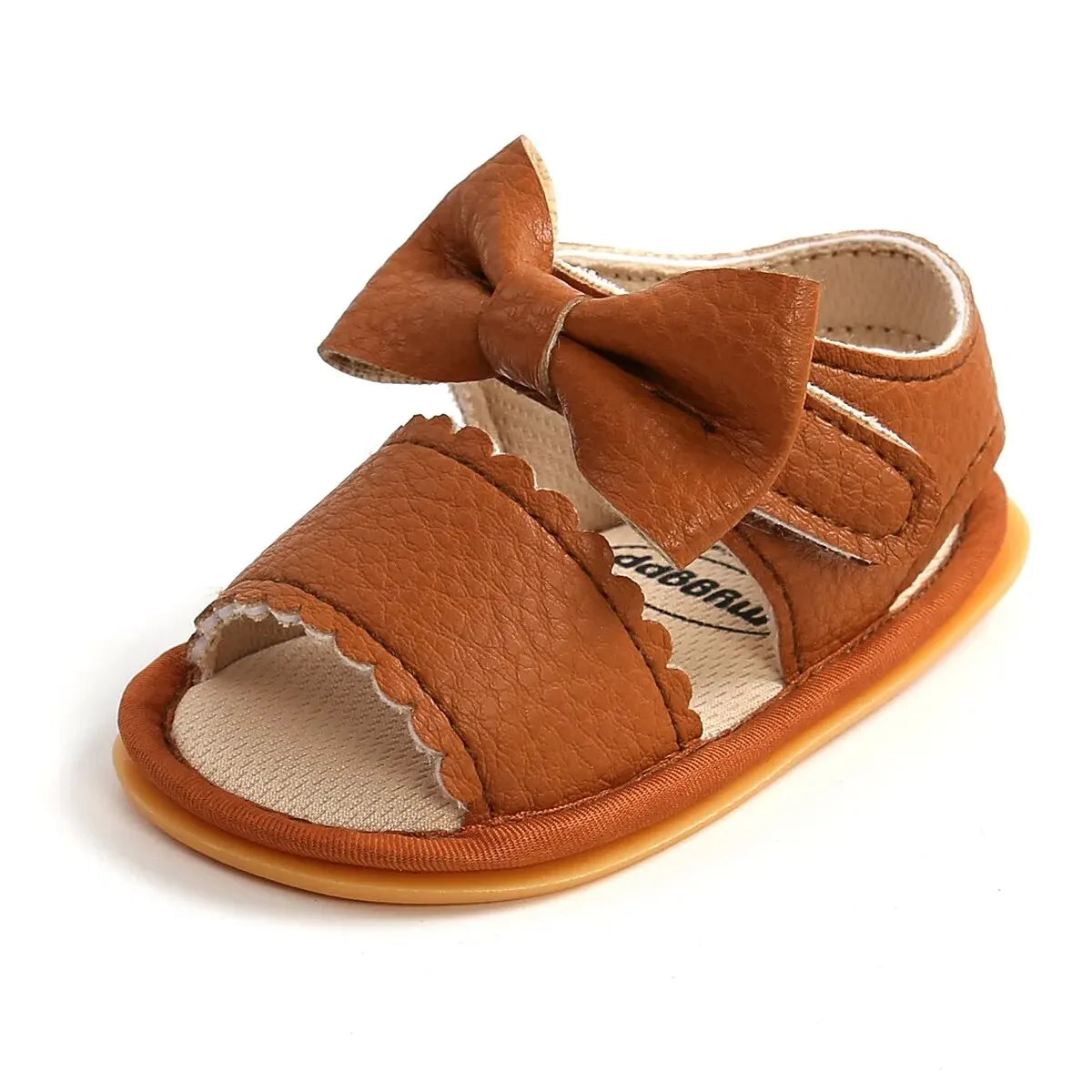 A cute pair of Bubebaby BabyLove  faux leather sandals for infants featuring an adorable bow detail. The sandals are designed for comfort and style, perfect for little ones to wear during warm weather. The adjustable strap ensures a secure fit while the soft sole provides cushioning for tiny feet